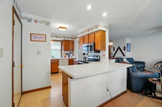 371 Federal Cir, Delaware, OH 43015 - kitchen featuring appliances with stainless steel finishes, open floor plan, a textured ceiling, light countertops, and a peninsula
