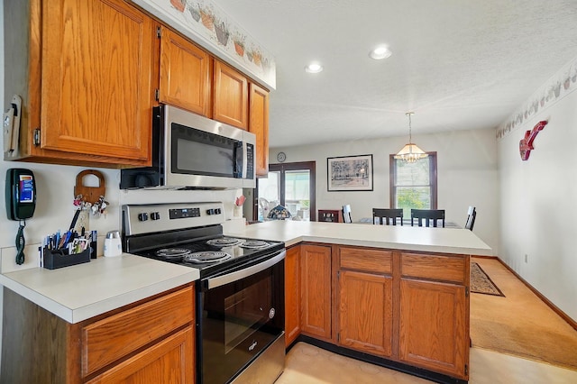371 Federal Cir, Delaware, OH 43015 - kitchen with appliances with stainless steel finishes, a peninsula, light countertops, brown cabinetry, and light colored carpet