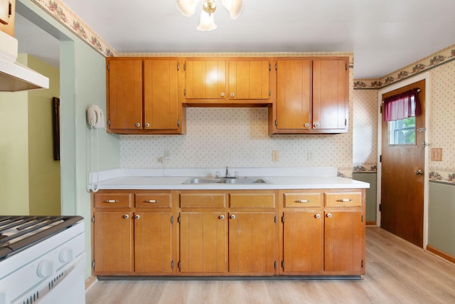 6082 Bolamo Ct, Westerville, OH 43081 - kitchen with wallpapered walls, a sink, light wood-type flooring, light countertops, and brown cabinets