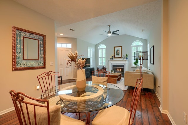 4115 Aumbrey Ct, New Albany, OH 43054 - dining area featuring dark wood-style floors, ceiling fan, baseboards, a warm lit fireplace, and vaulted ceiling