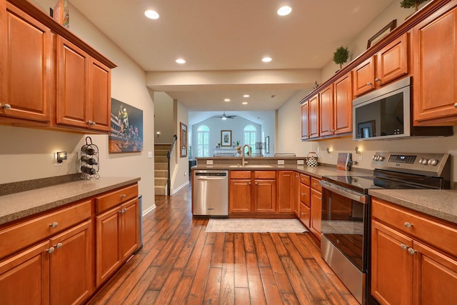 4115 Aumbrey Ct, New Albany, OH 43054 - kitchen with stainless steel appliances, a peninsula, dark wood-style flooring, a sink, and recessed lighting