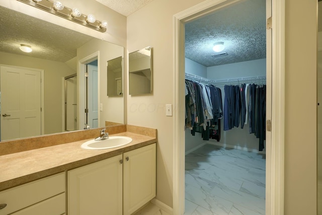 4115 Aumbrey Ct, New Albany, OH 43054 - full bathroom featuring a textured ceiling, marble look tiles, vanity, a walk in closet, and a shower stall