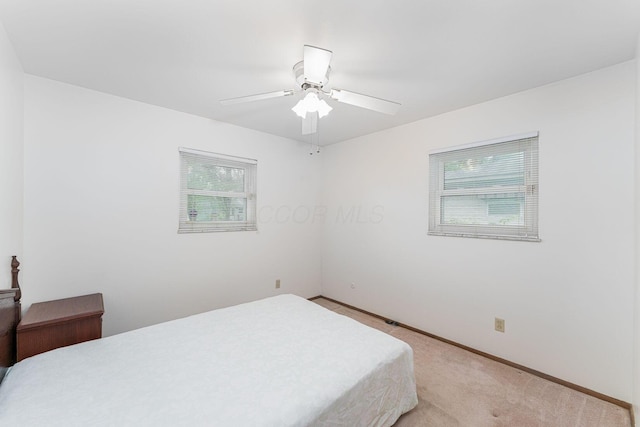 6241 Faircrest Rd, Columbus, OH 43229 - bedroom with multiple windows, light colored carpet, baseboards, and ceiling fan