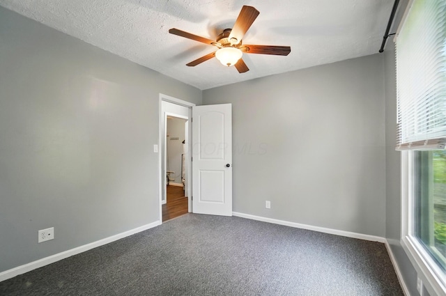 820 N Walnut St, Baltimore, OH 43105 - empty room featuring ceiling fan, dark colored carpet, and baseboards