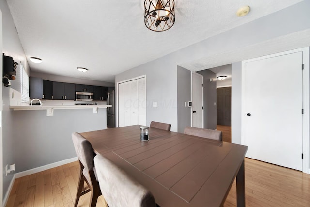 dining area featuring light wood-type flooring and baseboards