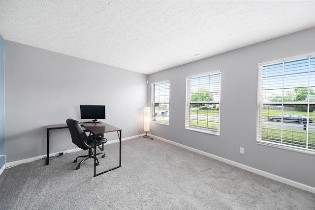 office space with carpet, baseboards, and a textured ceiling