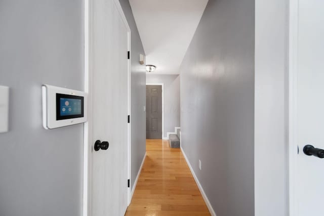 hall with light wood finished floors and baseboards