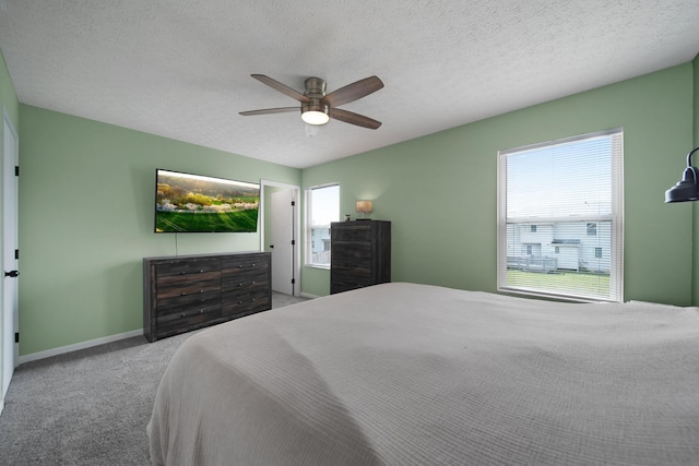 bedroom featuring carpet flooring, a ceiling fan, baseboards, and a textured ceiling