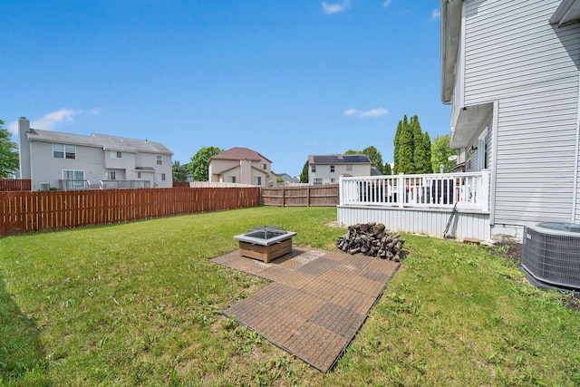 view of yard with central AC, a deck, and a fire pit