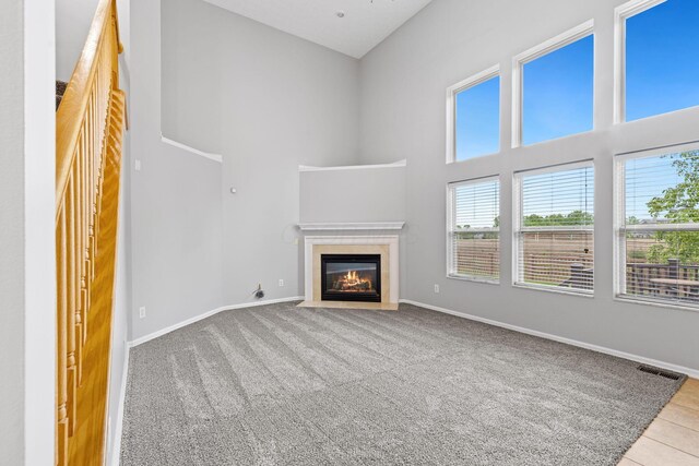 1980 Maxwell Ave, Lewis Center, OH 43035 - unfurnished living room featuring plenty of natural light, a fireplace with flush hearth, a high ceiling, and baseboards