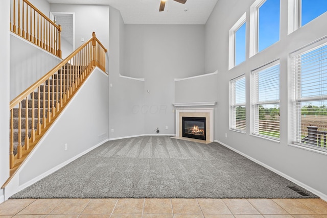 1980 Maxwell Ave, Lewis Center, OH 43035 - unfurnished living room featuring carpet, a ceiling fan, a high ceiling, baseboards, and a fireplace