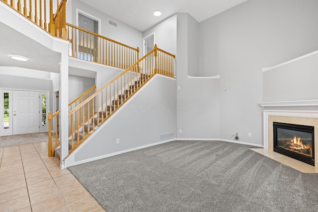 1980 Maxwell Ave, Lewis Center, OH 43035 - unfurnished living room with stairway, tile patterned floors, baseboards, a towering ceiling, and a fireplace with flush hearth