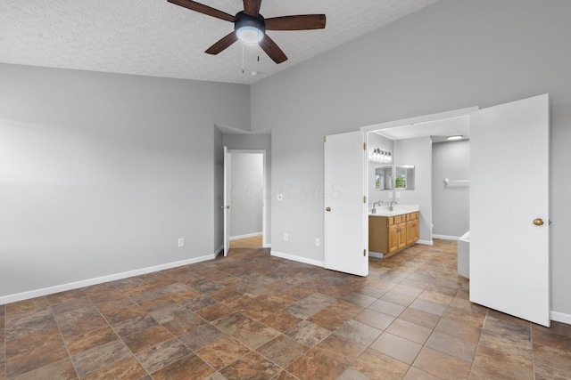 1980 Maxwell Ave, Lewis Center, OH 43035 - unfurnished bedroom featuring lofted ceiling, a textured ceiling, a sink, baseboards, and stone finish floors