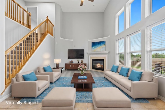 1980 Maxwell Ave, Lewis Center, OH 43035 - tiled living room with a towering ceiling, healthy amount of natural light, ceiling fan, a glass covered fireplace, and baseboards