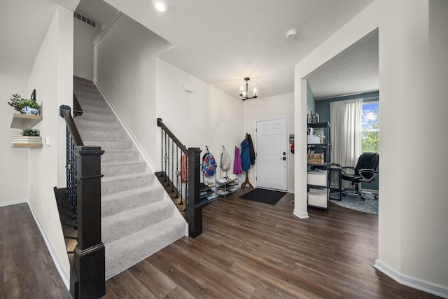 136 Bigelow Dr, Johnstown, OH 43031 - entryway featuring a chandelier, dark wood-style floors, stairs, and a textured ceiling