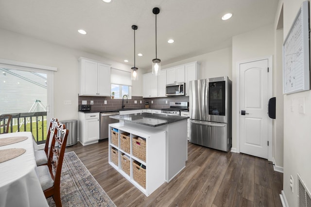 136 Bigelow Dr, Johnstown, OH 43031 - kitchen with appliances with stainless steel finishes, a sink, white cabinets, backsplash, and hanging light fixtures