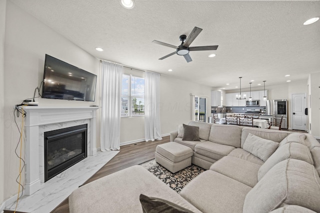 136 Bigelow Dr, Johnstown, OH 43031 - living room with ceiling fan, recessed lighting, a fireplace, a textured ceiling, and baseboards