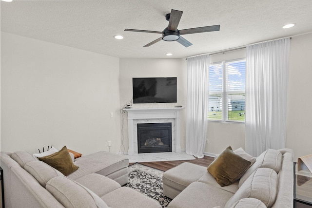 136 Bigelow Dr, Johnstown, OH 43031 - living room with wood finished floors, ceiling fan, recessed lighting, a textured ceiling, and a fireplace