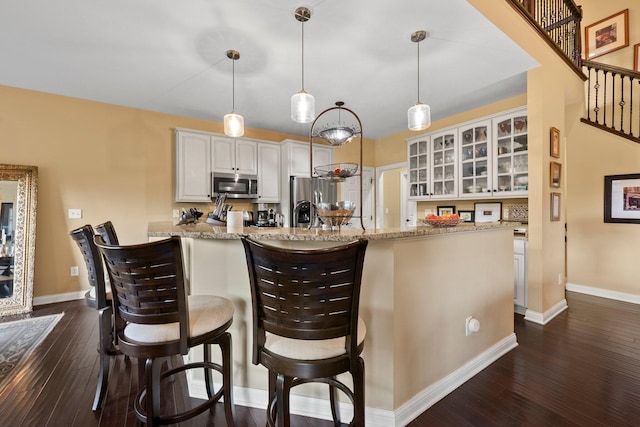 6755 Arbor View Ct, Powell, OH 43065 - kitchen featuring appliances with stainless steel finishes, glass insert cabinets, dark wood-style flooring, white cabinets, and baseboards