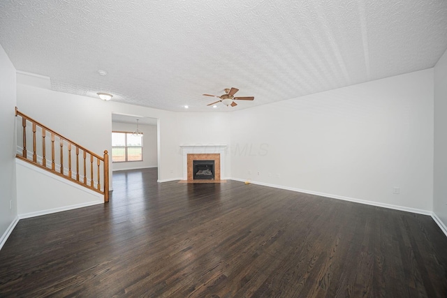 1019 Wallace Dr, Delaware, OH 43015 - unfurnished living room featuring a textured ceiling, dark wood finished floors, baseboards, ceiling fan, and a chandelier