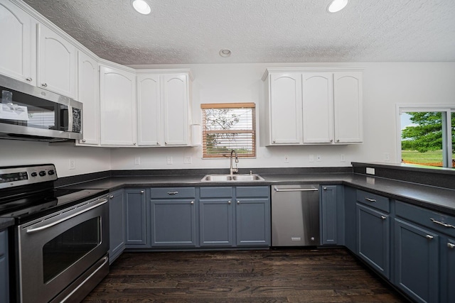 1019 Wallace Dr, Delaware, OH 43015 - kitchen with appliances with stainless steel finishes, a sink, white cabinets, dark countertops, and a textured ceiling