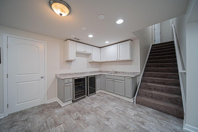 1019 Wallace Dr, Delaware, OH 43015 - kitchen featuring beverage cooler, gray cabinets, a sink, light wood finished floors, and baseboards