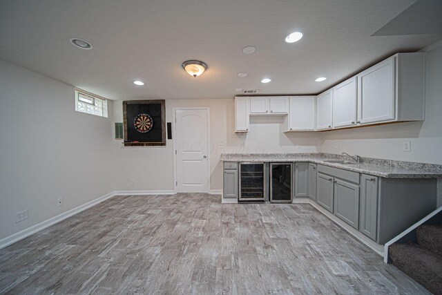 1019 Wallace Dr, Delaware, OH 43015 - kitchen featuring wine cooler, a sink, light wood-style flooring, baseboards, and recessed lighting