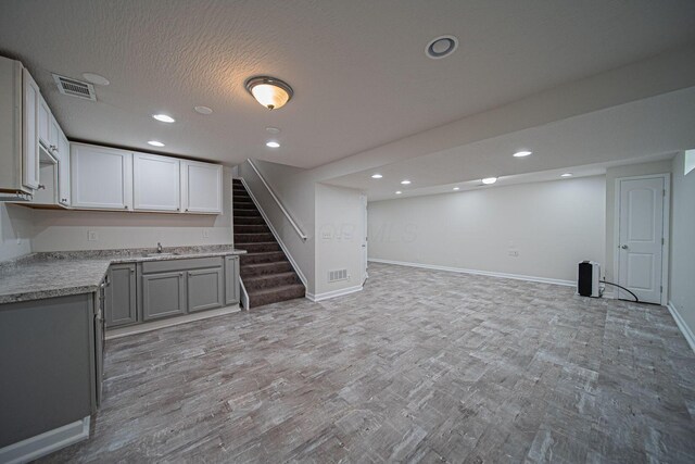 1019 Wallace Dr, Delaware, OH 43015 - kitchen featuring open floor plan, light countertops, baseboards, gray cabinetry, and light wood-style floors