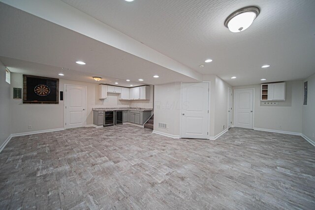 1019 Wallace Dr, Delaware, OH 43015 - finished basement featuring light wood finished floors, baseboards, recessed lighting, and beverage cooler
