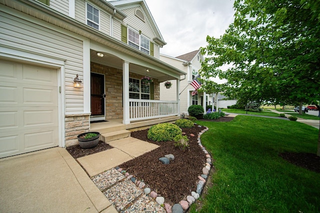 1019 Wallace Dr, Delaware, OH 43015 - doorway to property with a porch, a garage, stone siding, and a lawn