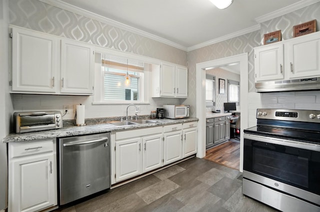 114 Roosevelt Dr, Springfield, OH 45504 - kitchen featuring appliances with stainless steel finishes, a sink, under cabinet range hood, white cabinetry, and crown molding