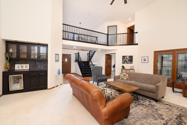 5754 N Loch Maree Ct N, Dublin, OH 43017 - carpeted living room featuring stairs, ceiling fan, a towering ceiling, and baseboards
