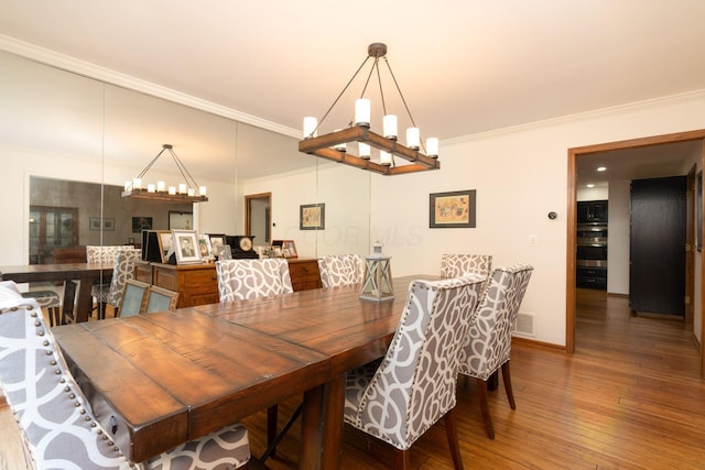 5754 N Loch Maree Ct N, Dublin, OH 43017 - dining space with ornamental molding, wood finished floors, a chandelier, and baseboards
