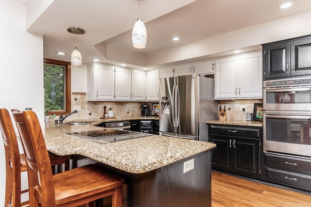 5754 N Loch Maree Ct N, Dublin, OH 43017 - kitchen featuring stainless steel appliances, a sink, dark cabinetry, white cabinetry, and recessed lighting