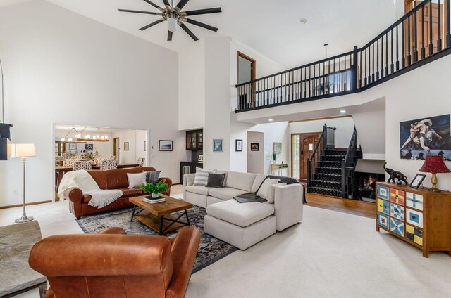 5754 N Loch Maree Ct N, Dublin, OH 43017 - living area featuring a towering ceiling, stairway, a ceiling fan, a chandelier, and carpet flooring