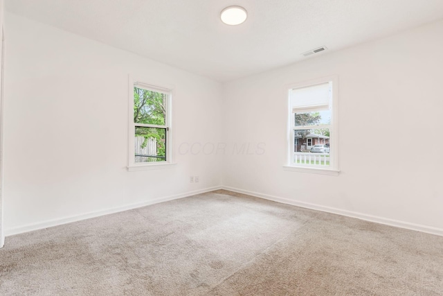 unfurnished room featuring carpet floors and baseboards