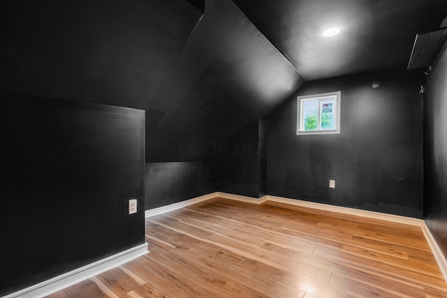 bonus room featuring vaulted ceiling, hardwood / wood-style flooring, and baseboards
