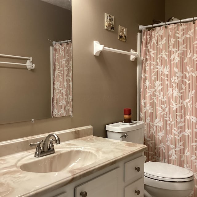bathroom with toilet, vanity, and curtained shower