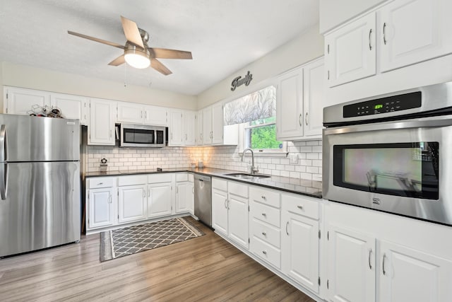 499 Wickham Way, Columbus, OH 43230 - kitchen featuring stainless steel appliances, a sink, dark countertops, and white cabinets