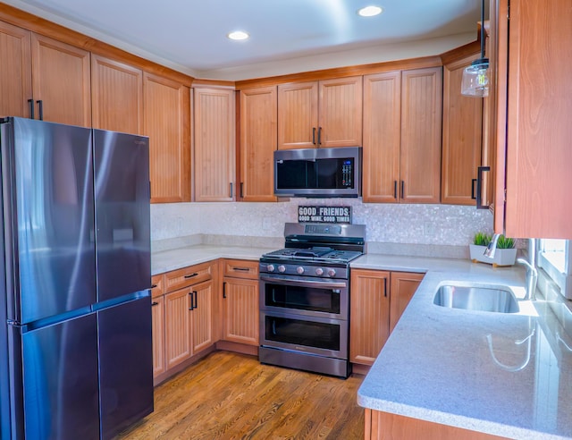 163 E 3rd Ave, Columbus, OH 43201 - kitchen featuring stainless steel appliances, a sink, light wood-style floors, recessed lighting, and light stone counters