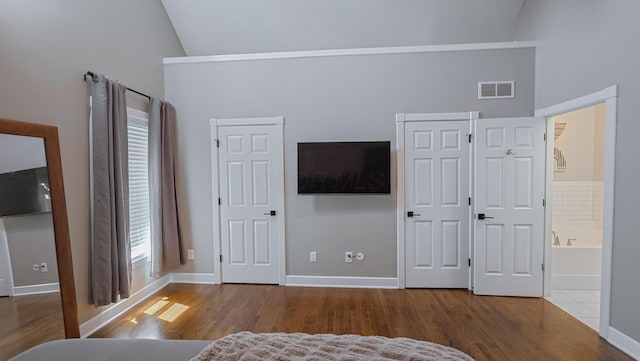 163 E 3rd Ave, Columbus, OH 43201 - bedroom with wood finished floors, high vaulted ceiling, baseboards, ensuite bathroom, and multiple closets