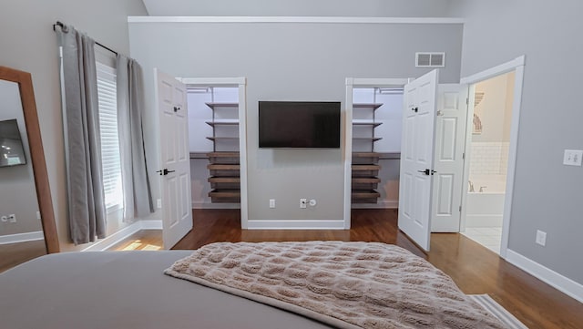 163 E 3rd Ave, Columbus, OH 43201 - bedroom with a walk in closet, wood finished floors, baseboards, and ensuite bathroom