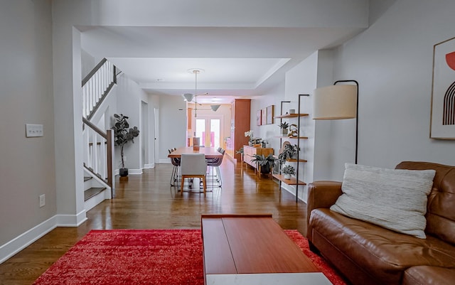 163 E 3rd Ave, Columbus, OH 43201 - living area featuring stairs, dark wood-type flooring, baseboards, and a raised ceiling