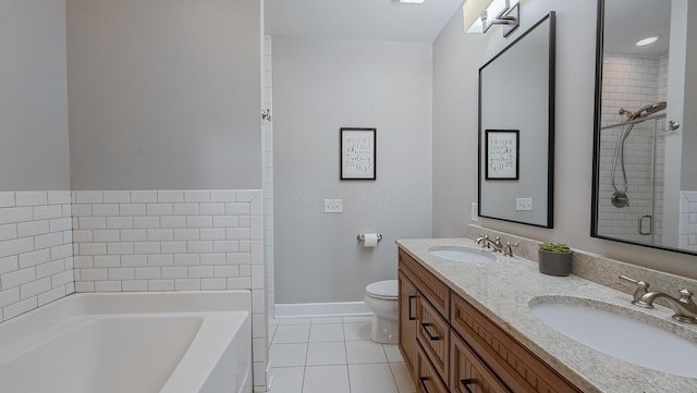 163 E 3rd Ave, Columbus, OH 43201 - full bathroom with tile patterned flooring, a garden tub, toilet, double vanity, and baseboards