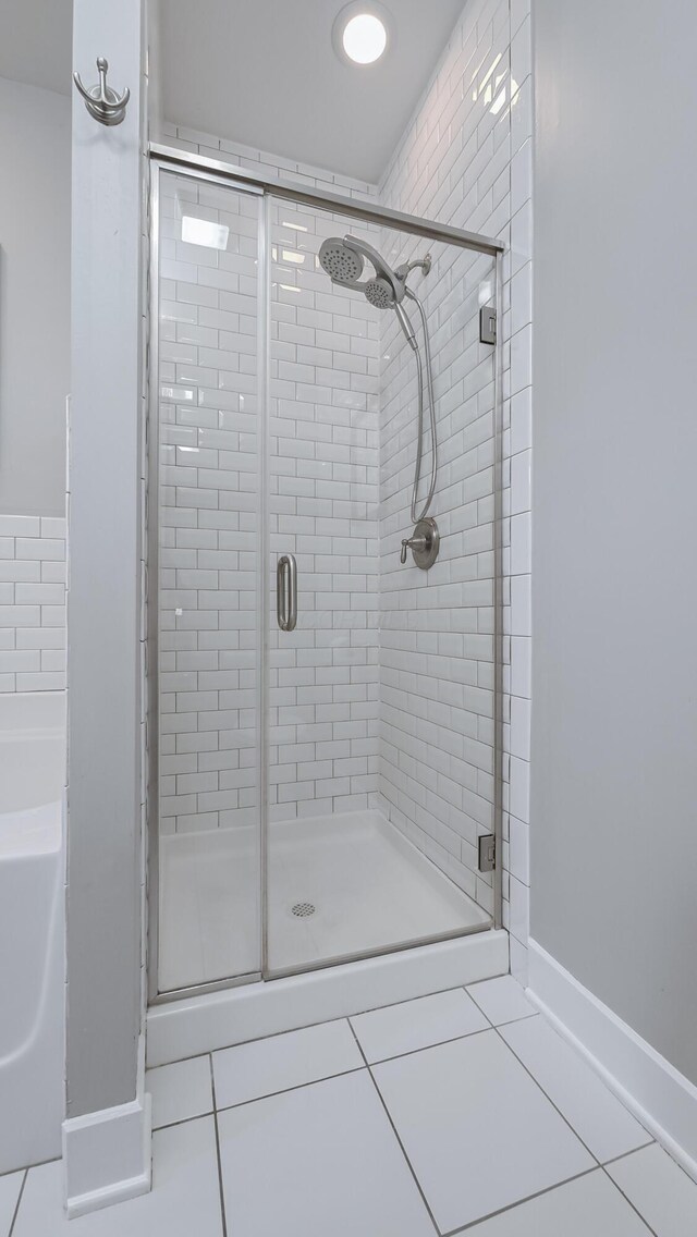 163 E 3rd Ave, Columbus, OH 43201 - bathroom featuring tile patterned flooring, a shower stall, a bath, and baseboards