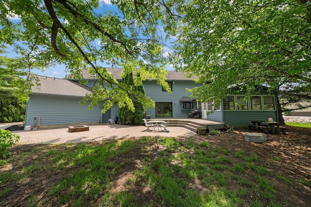 5657 Freeman Rd, Westerville, OH 43082 - rear view of house featuring an outdoor fire pit, a sunroom, a patio, and a wooden deck