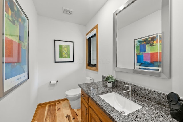 5657 Freeman Rd, Westerville, OH 43082 - half bath featuring wood finished floors, toilet, baseboards, and vanity