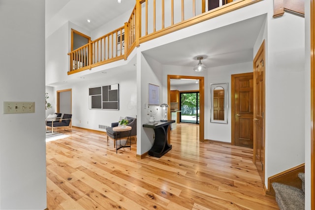 5657 Freeman Rd, Westerville, OH 43082 - foyer with light wood-style floors, stairway, a high ceiling, and baseboards