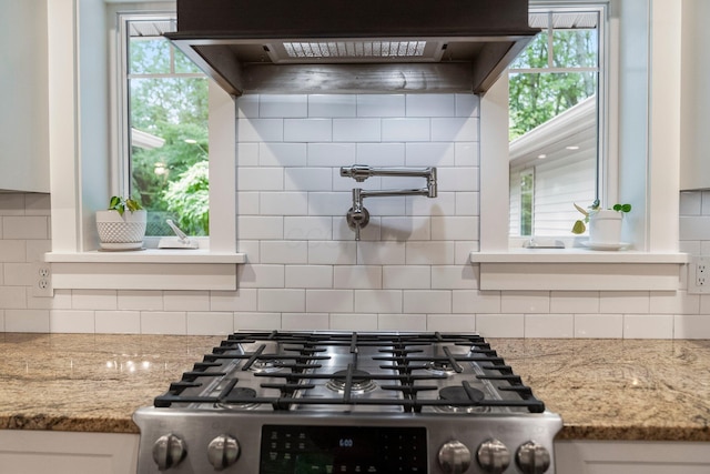 429 N Old State Rd, Delaware, OH 43015 - kitchen view of stainless steel gas range oven, pot filler, under cabinet range hood, backsplash, and white cabinets