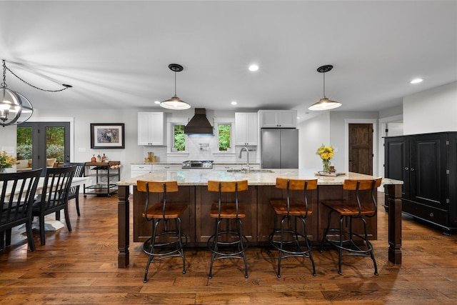 429 N Old State Rd, Delaware, OH 43015 - kitchen with stainless steel appliances, custom range hood, a sink, a large island with sink, and white cabinetry